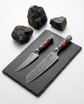 Set 2 couteaux japonais damas, kiritsuke et petty, manches résine noir et ambre sur ardoise avec pierres volcaniques.