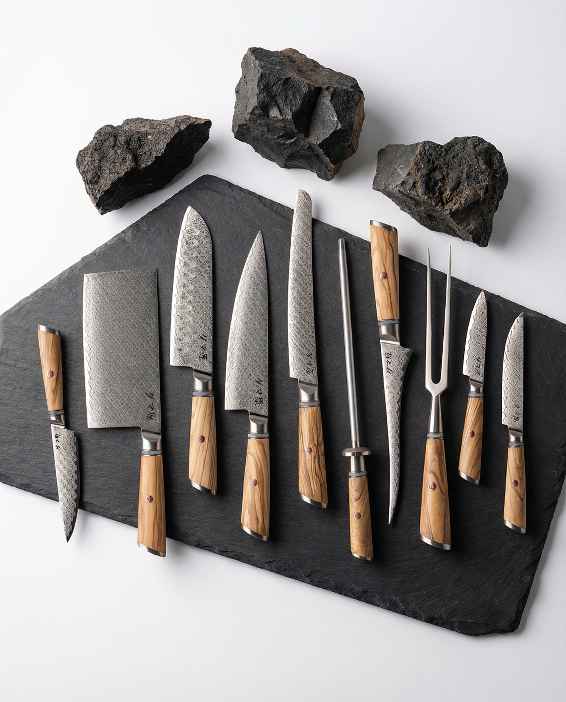 Set de 10 couteaux japonais en acier damas, manches bois clair, incluant chef, santoku, kiritsuke, nakiri, petty et fusil, sur ardoise.