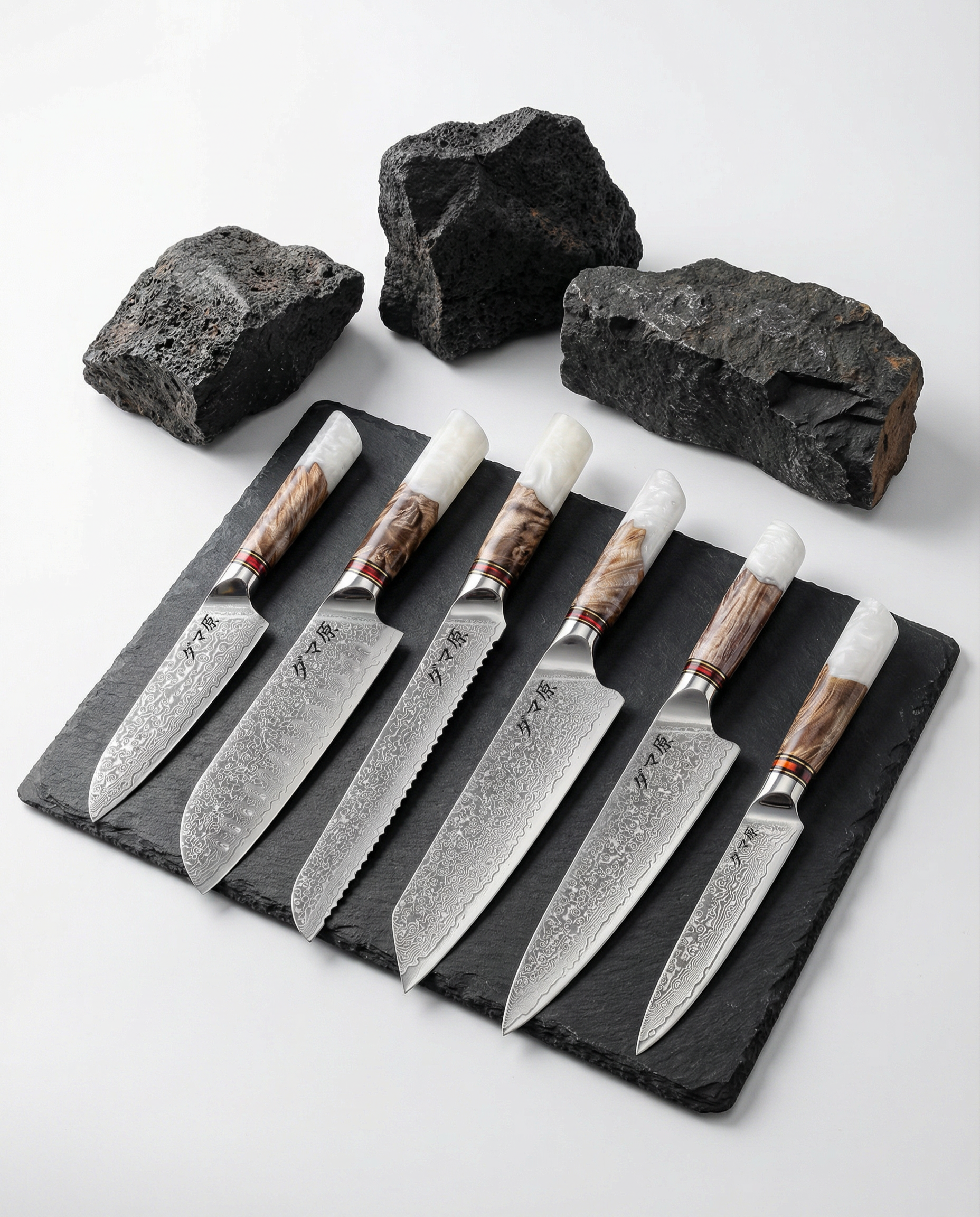 Set de 6 couteaux japonais damas avec manches bois et résine blanche, présentés sur ardoise noire et pierres brutes.