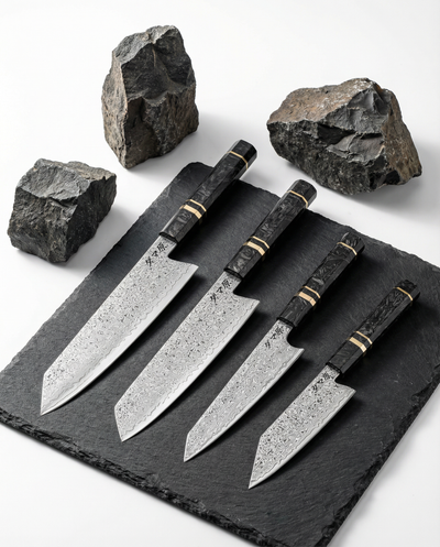 set de couteaux japonais en acier damassé avec manches noirs veinés, posés sur ardoise noire entourée de pierres brutes