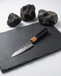Couteau japonais en damas type office avec lame martelée artisanale et manche bois octogonal, précision et tranchant professionnel.