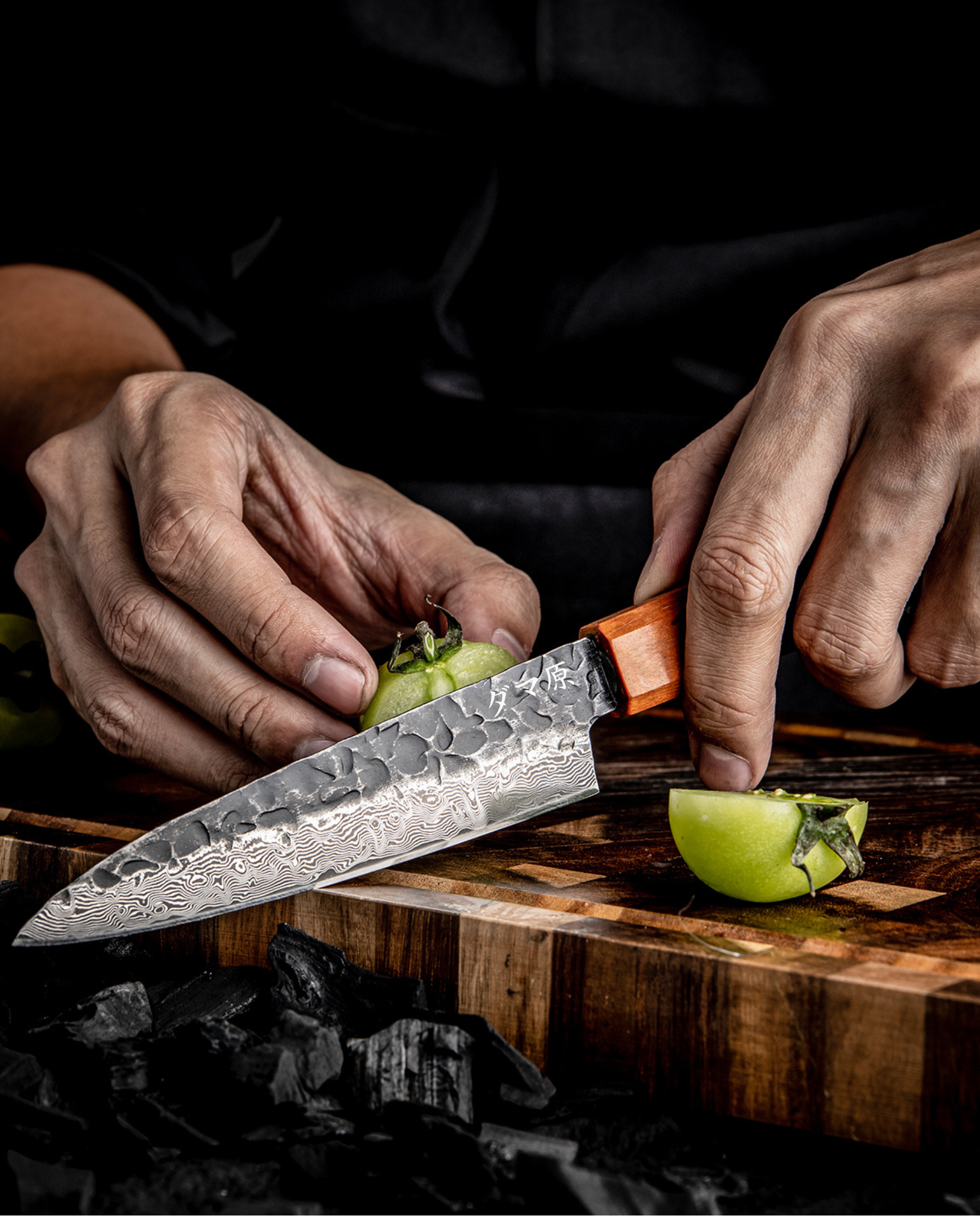Couteau japonais en damas Petty en action, lame martelée ultra tranchante pour découpe précise de légumes sur planche en bois.