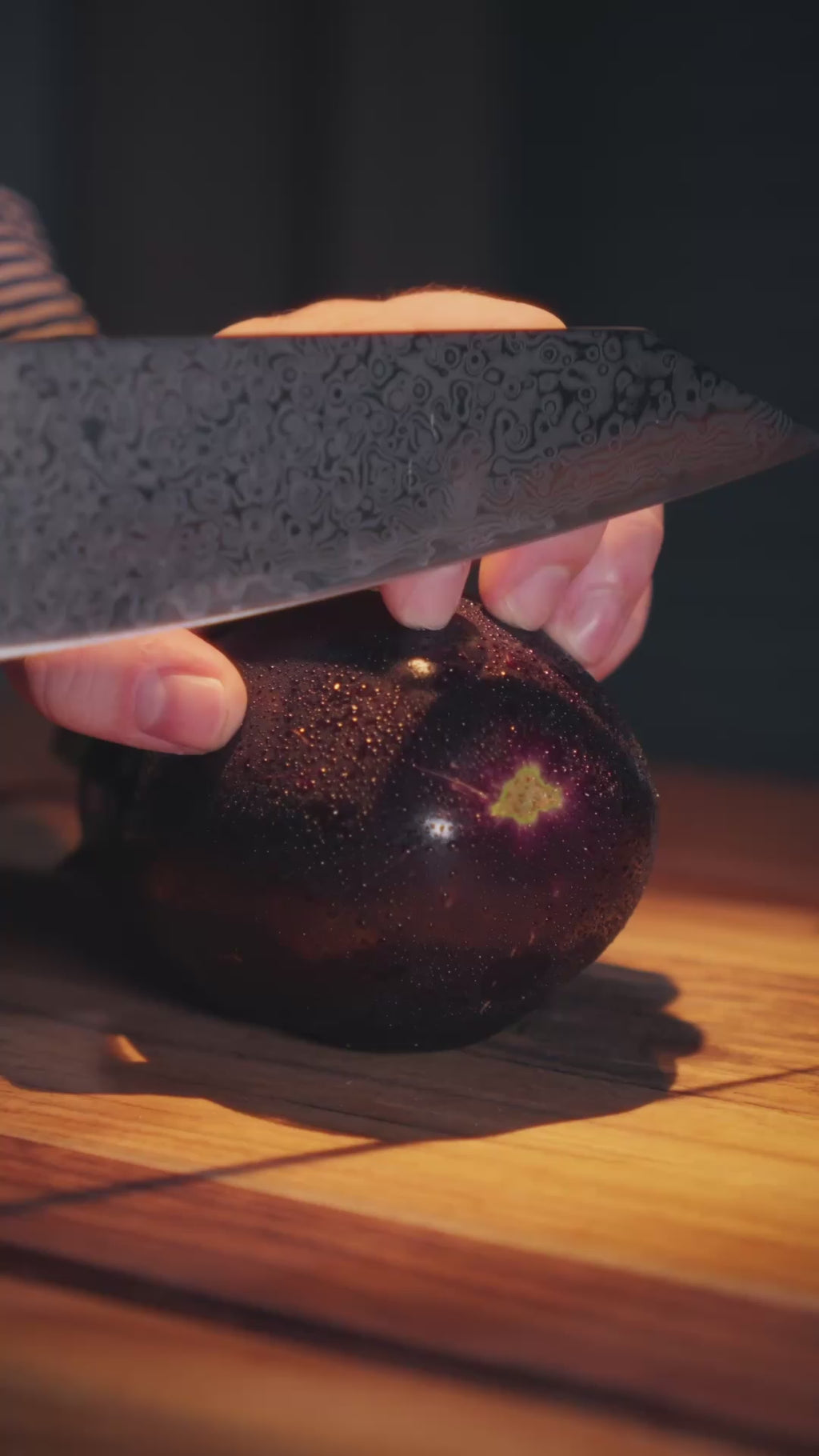Découpe d'une aubergine en tranches fines avec un couteau en acier damas Damas Origin