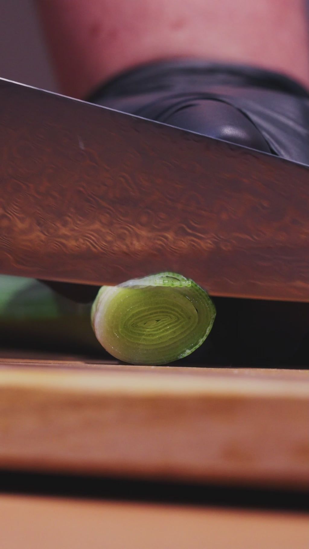 Découpe nette d'un légume avec un couteau en acier damas Damas Origin