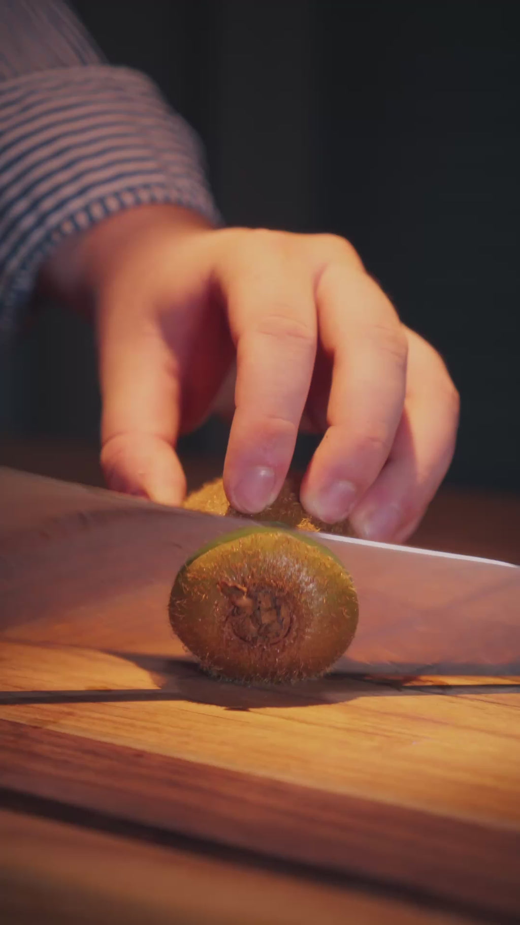 Découpe d'un kiwi avec un couteau en acier damas de la série Aoyama