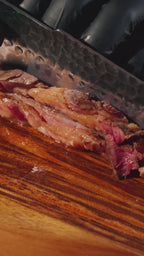 Découpe d'une pièce de viande avec un couteau en acier damas Damas Origin